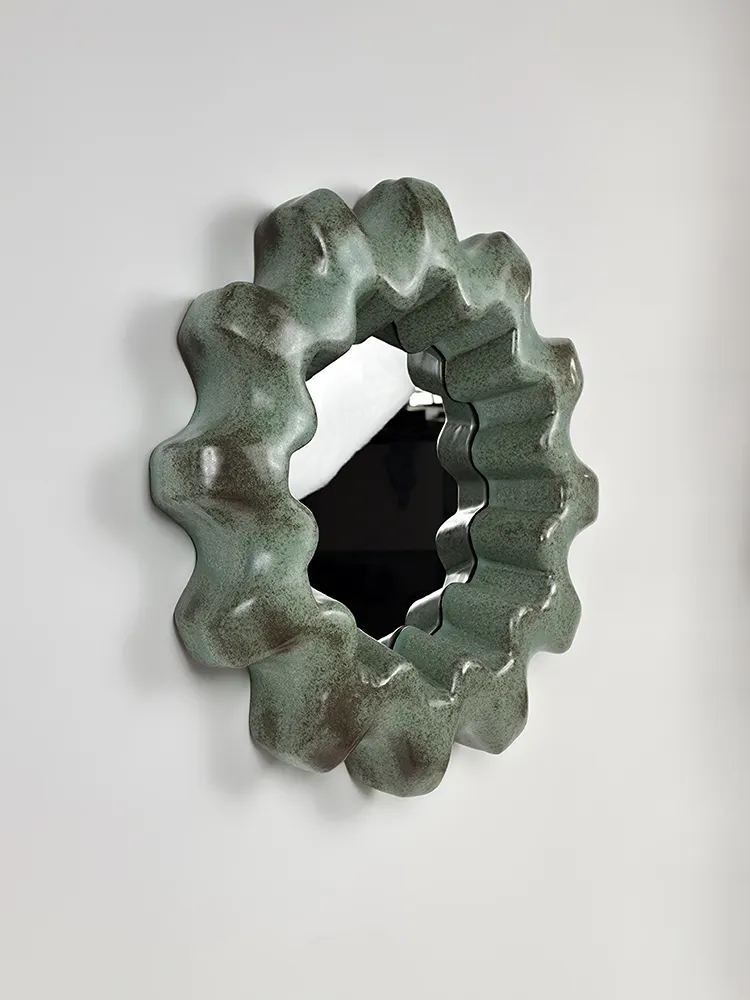 Miroir Arasaka vu de trois quarts avec cadre ondulé en céramique émaillée verte