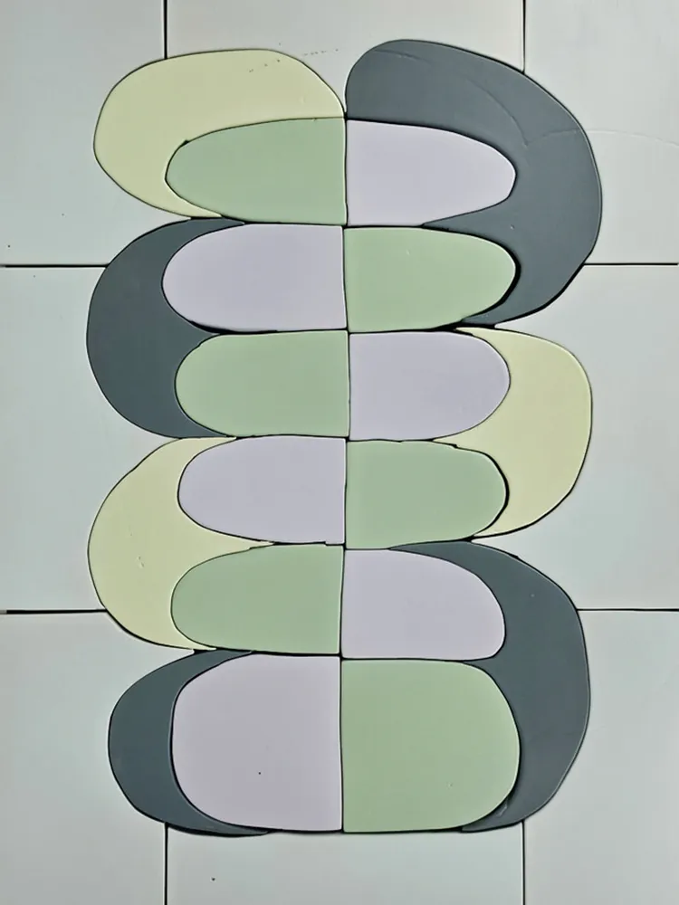 Étude de céramique murale composée de formes entrelacées vertes, grises et lilas