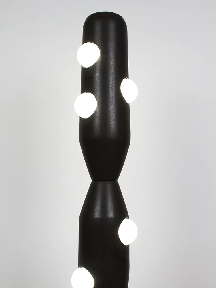 Lampadaire Odrade allumé avec structure noire en grès émaillé en gros plan