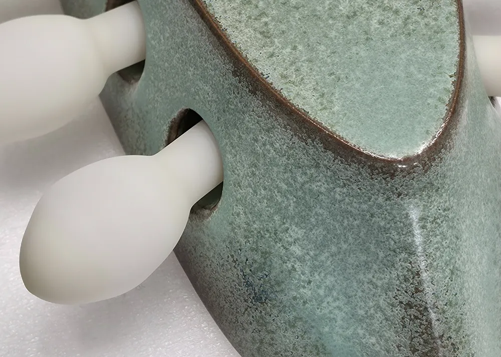 Détail d’une pièce en céramique émaillée associée à des éléments en verre