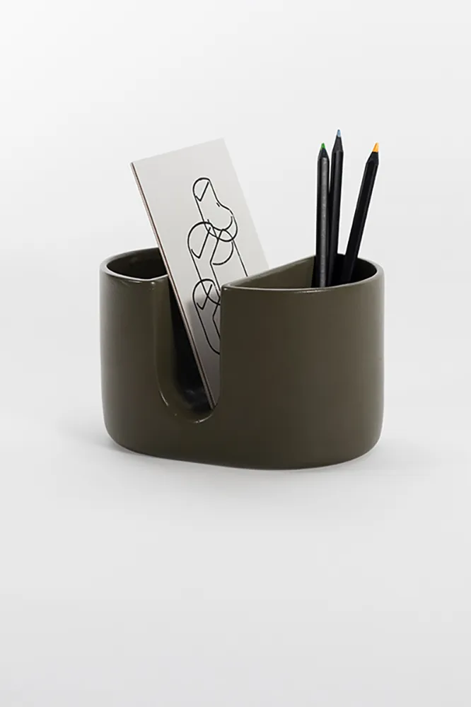 Contenant Shells en céramique vert foncé utilisé pour ranger des crayons et une carte