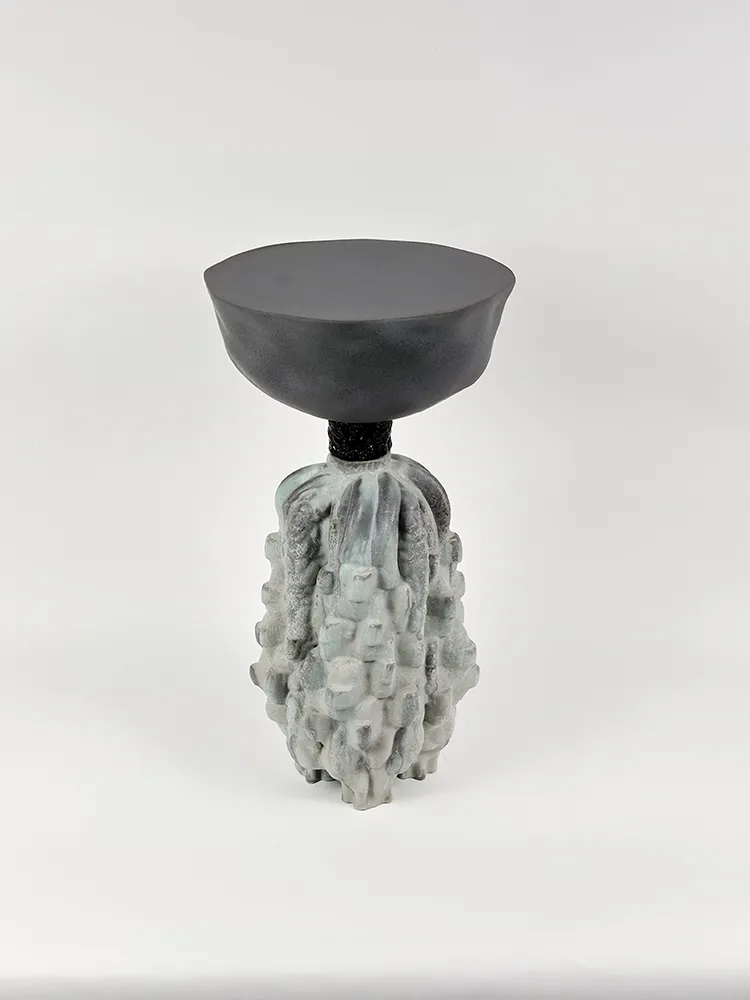 Vue d’ensemble de la Table Totem 4 avec plateau noir et piètement sculptural en céramique gris vert